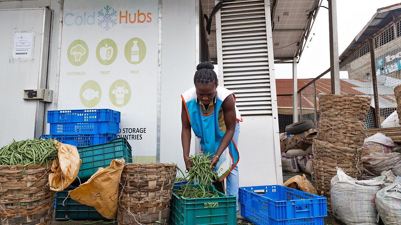 Woman with fresh vedetables outside a Cold Hub.