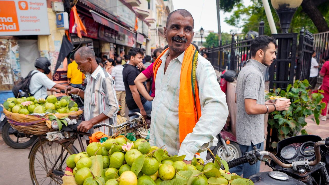 An Indian fruit seller offers guava on a motorcycle in the Hazratganj shopping area in Lucknow