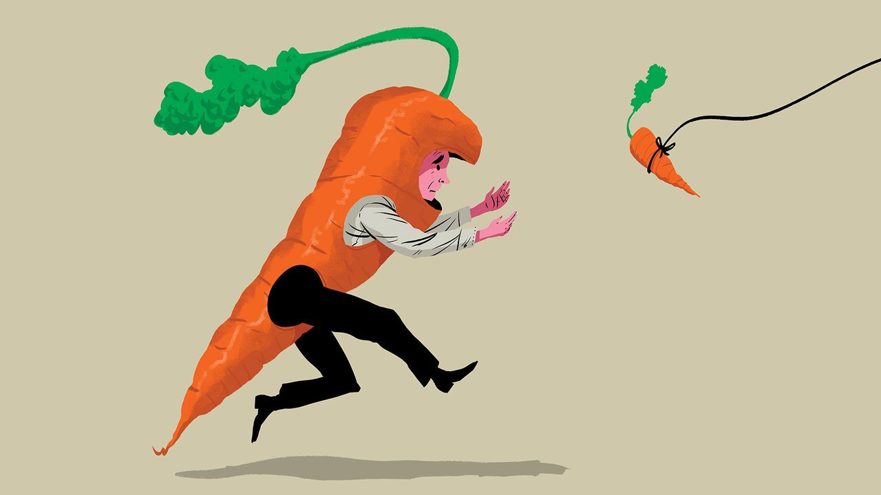 A man dressed as a carrot chasing a carrot dangling in front of him.