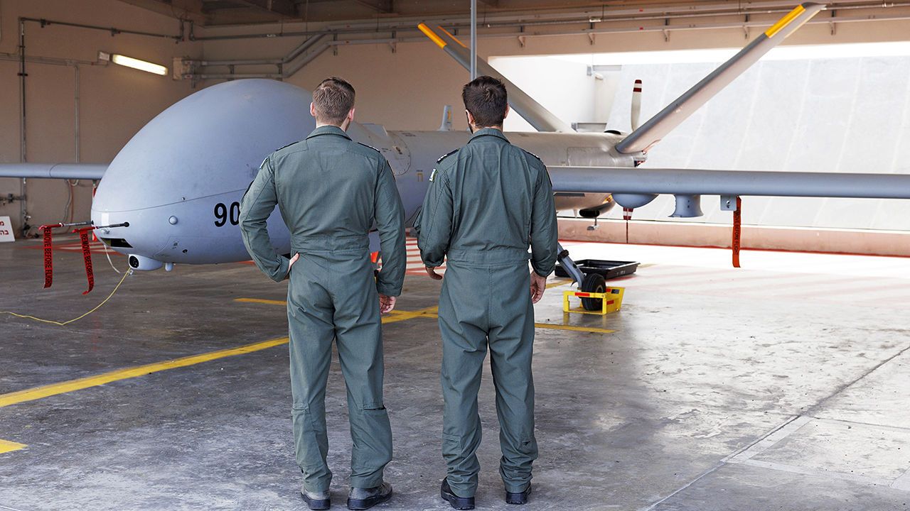 Israeli Air Force drone pilots stand beside a Hermes 900 unmanned aerial vehicle at Palmachim Airbase in Palmachim, Israel.