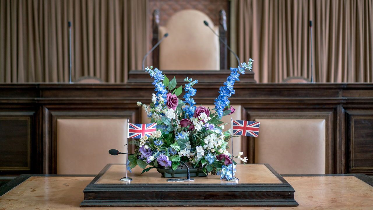 Flowers and Union Jack flags on a lectern where a citizenship ceremony.