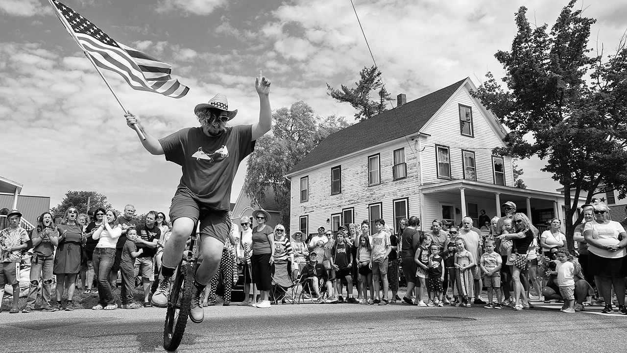 A man holds a flag whilst riding a unicycle at the Inedpendence Day parade in Ocean Park.